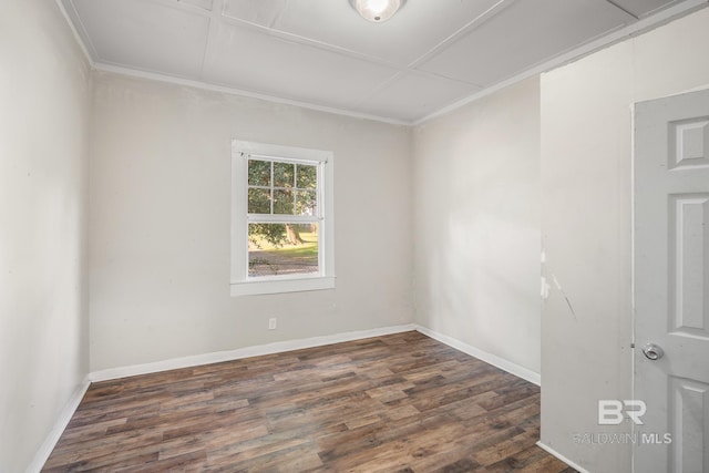 spare room featuring crown molding and dark wood-type flooring