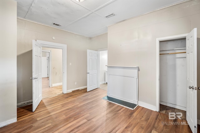 unfurnished bedroom with a closet and hardwood / wood-style floors