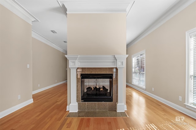 unfurnished living room featuring a fireplace, light hardwood / wood-style flooring, and ornamental molding