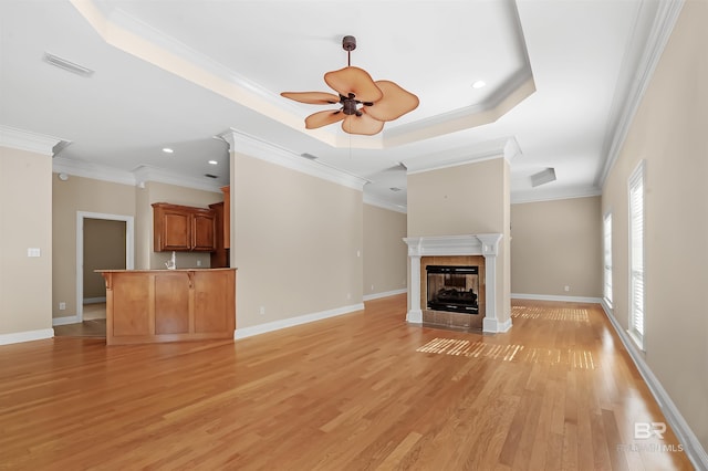 unfurnished living room featuring a fireplace, light wood-type flooring, ceiling fan, and ornamental molding