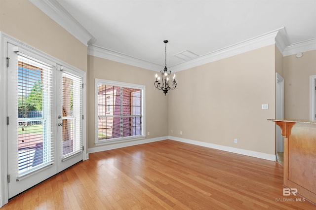 unfurnished dining area featuring an inviting chandelier, crown molding, and light hardwood / wood-style flooring