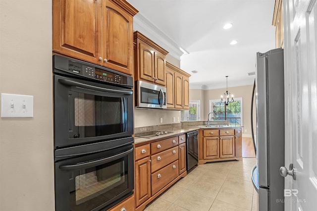 kitchen featuring pendant lighting, black appliances, crown molding, sink, and a notable chandelier