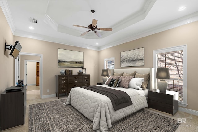 bedroom with a tray ceiling, dark carpet, ceiling fan, and ornamental molding