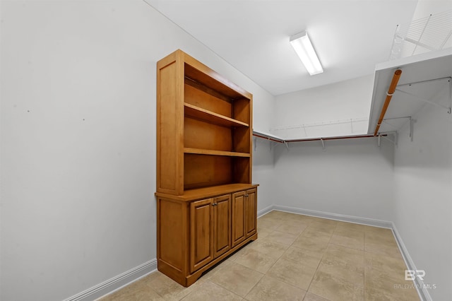 walk in closet with light tile patterned floors