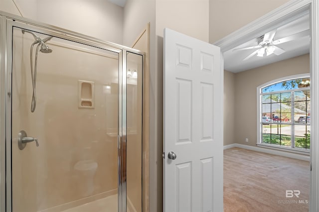 bathroom with a shower with door and ceiling fan