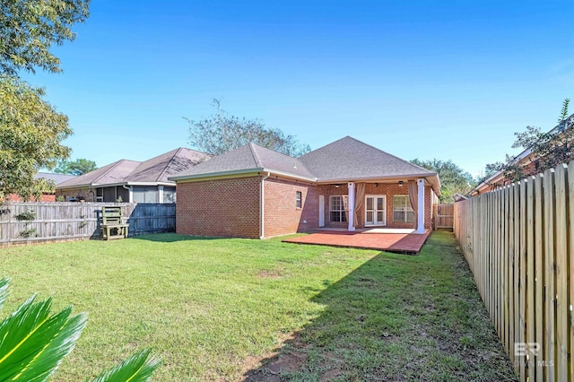 back of property featuring a patio area and a yard