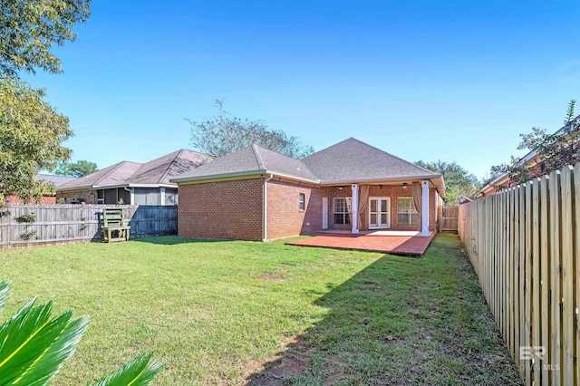 rear view of house featuring a patio and a yard