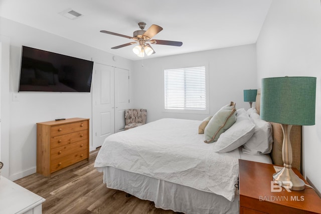 bedroom featuring hardwood / wood-style flooring, ceiling fan, and a closet