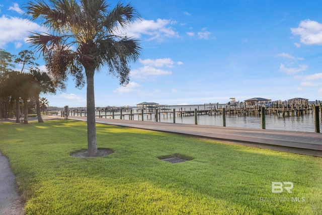 view of dock featuring a yard and a water view