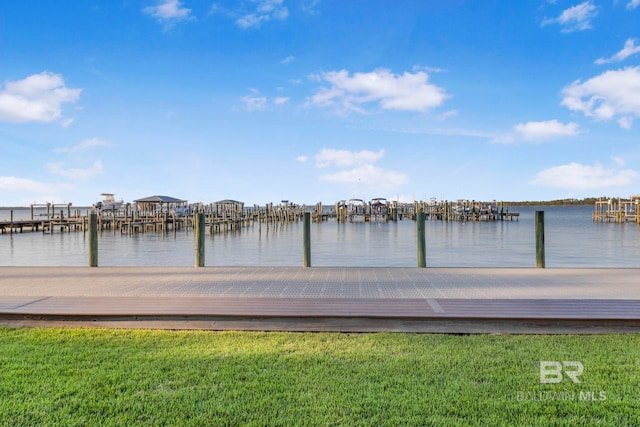 view of dock with a water view and a lawn