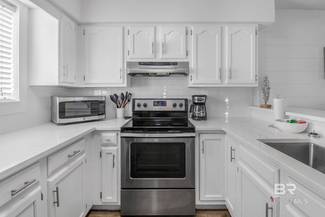 kitchen with backsplash, stainless steel appliances, sink, and white cabinets