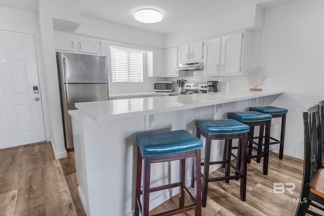 kitchen featuring white cabinetry, appliances with stainless steel finishes, and kitchen peninsula