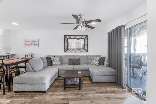 living room featuring wood-type flooring and ceiling fan