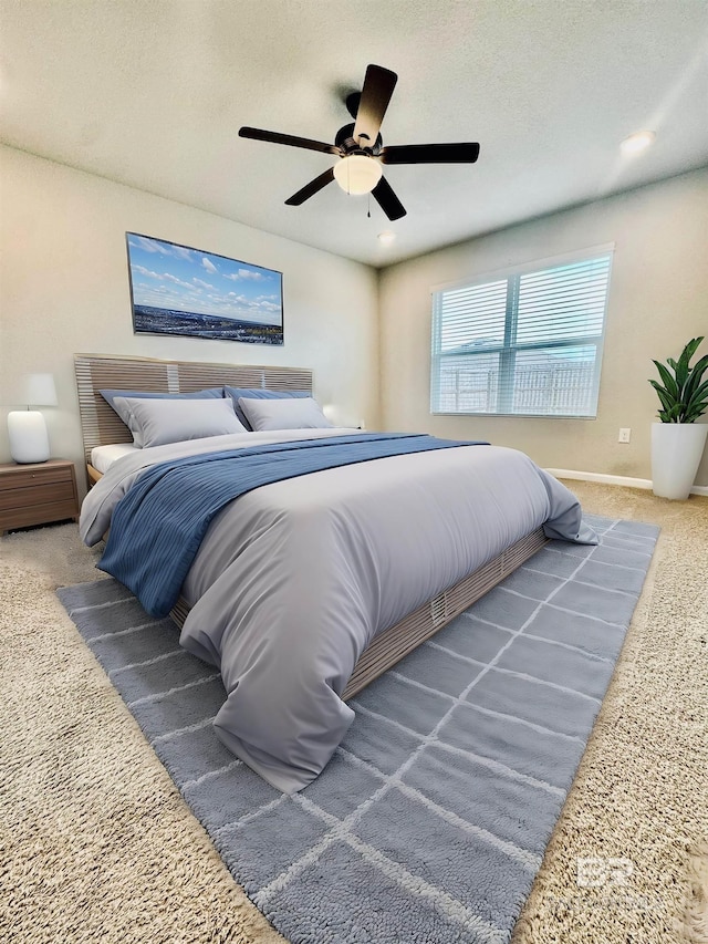 carpeted bedroom with ceiling fan and a textured ceiling