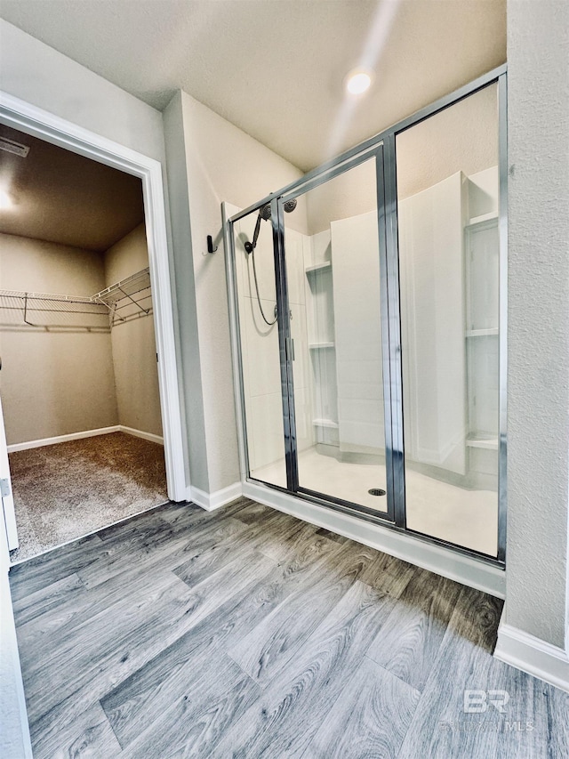 bathroom with an enclosed shower and wood-type flooring