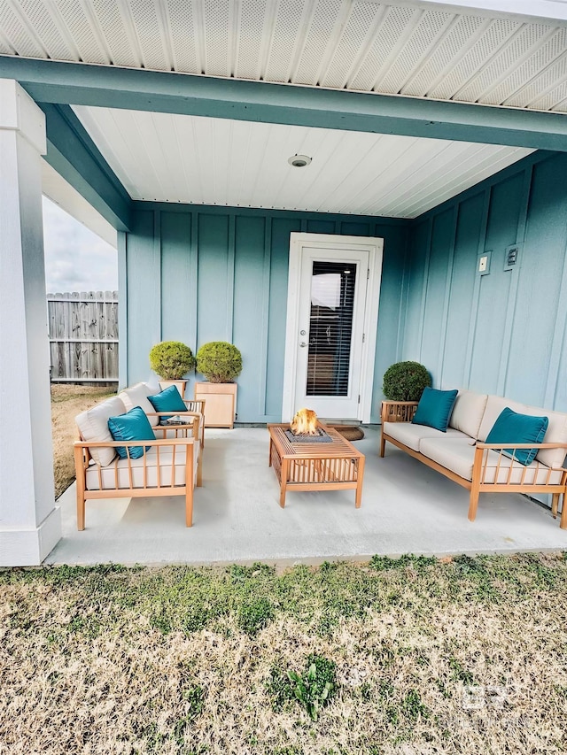 view of patio with an outdoor living space with a fire pit