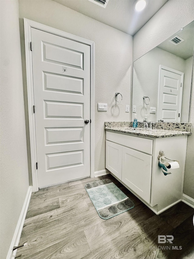 bathroom with vanity and wood-type flooring