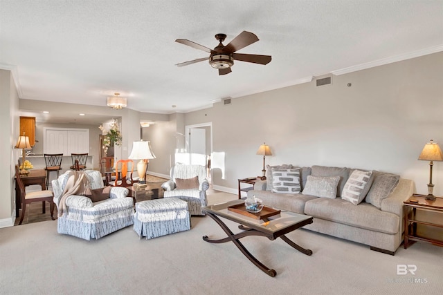 living room featuring ceiling fan, a textured ceiling, and crown molding