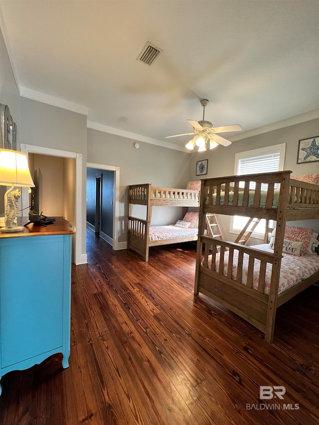 bedroom featuring ornamental molding, ceiling fan, and dark wood-type flooring