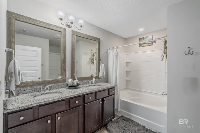 bathroom with shower / tub combo with curtain, vanity, and a textured ceiling