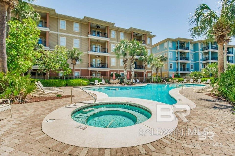 view of pool with a hot tub and a patio