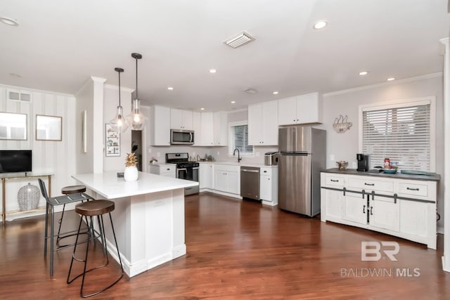 1 Elizabeth Pl, Mobile, AL 36606 - kitchen with appliances with stainless steel finishes, crown molding, white cabinets, a sink, and pendant lighting