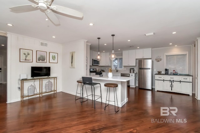1 Elizabeth Pl, Mobile, AL 36606 - kitchen featuring appliances with stainless steel finishes, a peninsula, a breakfast bar, ceiling fan, and light countertops