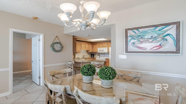 dining space featuring a chandelier, sink, a textured ceiling, and light tile patterned floors