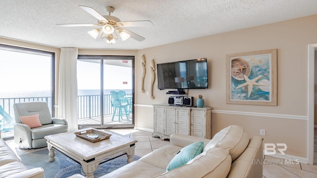 tiled living room featuring ceiling fan and a textured ceiling