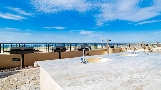 view of patio / terrace with a water view and sink