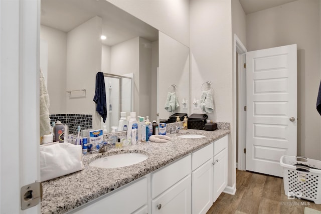 bathroom featuring a shower with door, hardwood / wood-style floors, and vanity