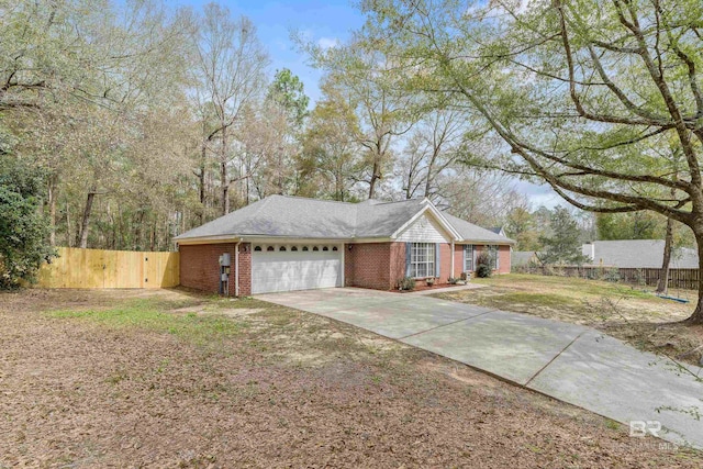 exterior space with a garage, brick siding, concrete driveway, and fence