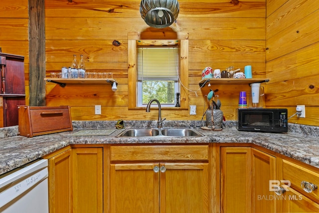 kitchen featuring wood walls, sink, and white dishwasher