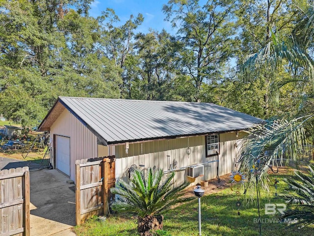 view of outbuilding featuring a garage, a yard, and a wall mounted AC