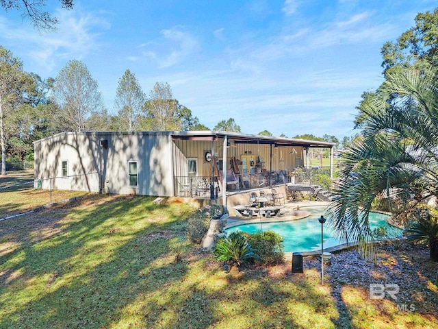 rear view of house featuring a lawn and a patio