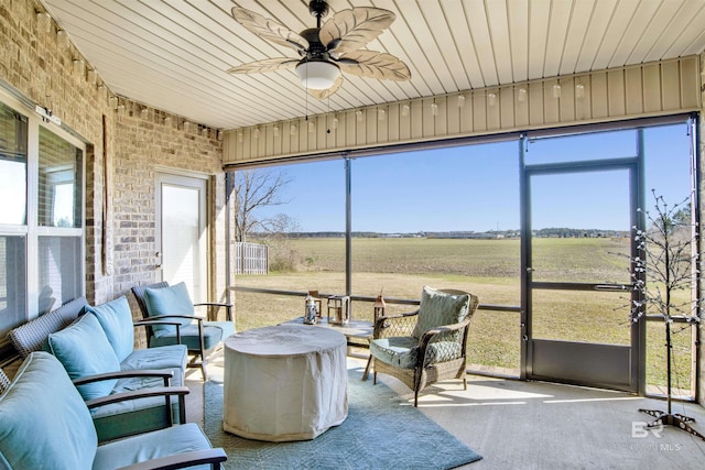 sunroom / solarium with a wealth of natural light, a rural view, and ceiling fan