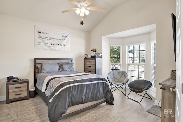 bedroom featuring ceiling fan, light hardwood / wood-style floors, and vaulted ceiling