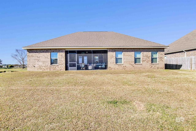 back of house with a sunroom and a lawn