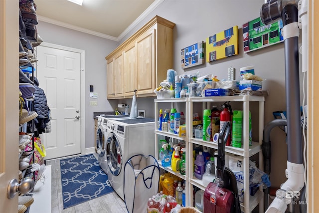 laundry room with cabinets, light hardwood / wood-style floors, crown molding, and washer and clothes dryer