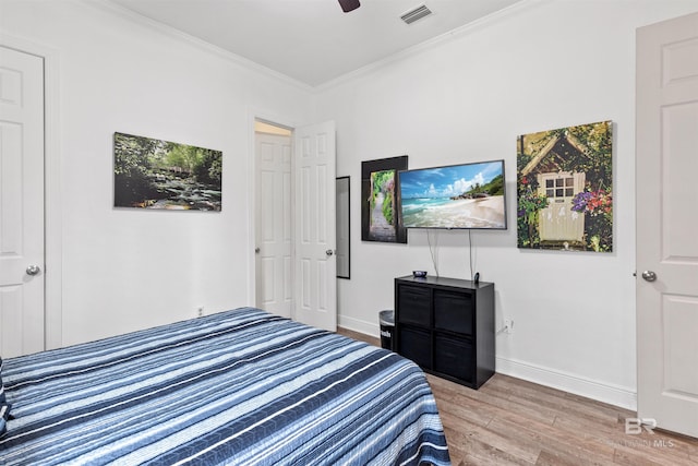 bedroom featuring ornamental molding, ceiling fan, and light wood-type flooring