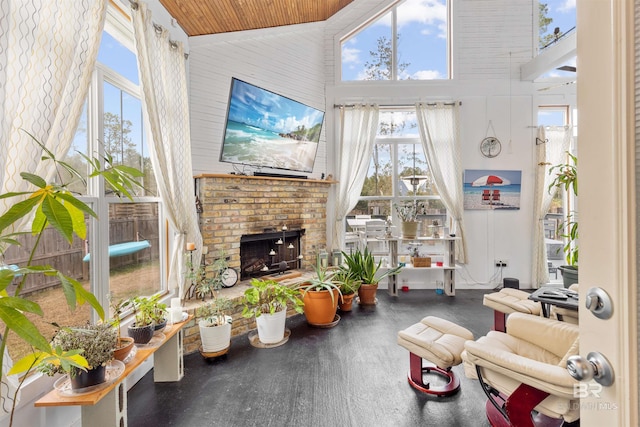 sunroom / solarium with lofted ceiling, a fireplace, and wood ceiling