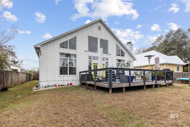 rear view of house featuring a lawn and a wooden deck