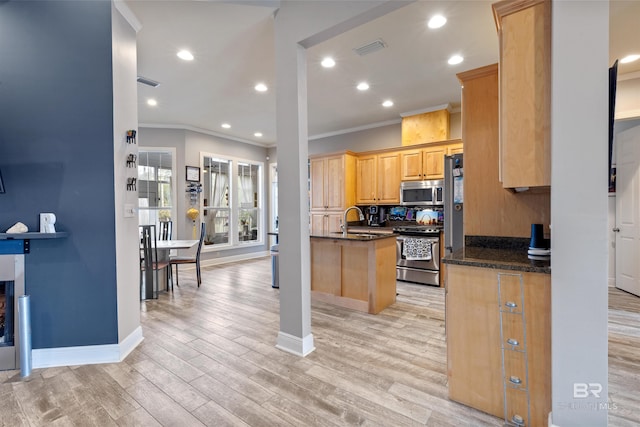 kitchen with stainless steel appliances, dark stone counters, ornamental molding, and light hardwood / wood-style floors