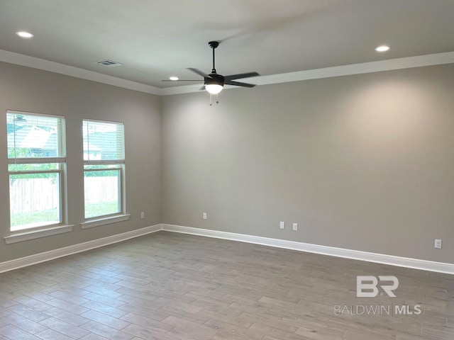 spare room with ceiling fan, ornamental molding, and light hardwood / wood-style floors