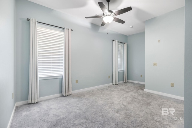 carpeted empty room with baseboards and ceiling fan