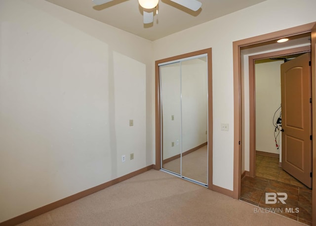 unfurnished bedroom featuring carpet flooring, ceiling fan, and a closet