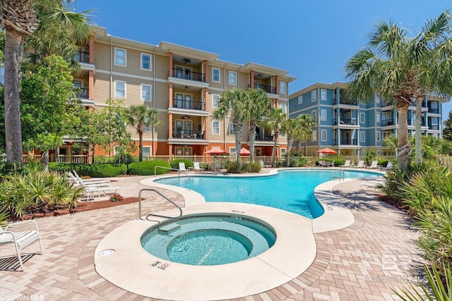 view of pool with a patio and a hot tub