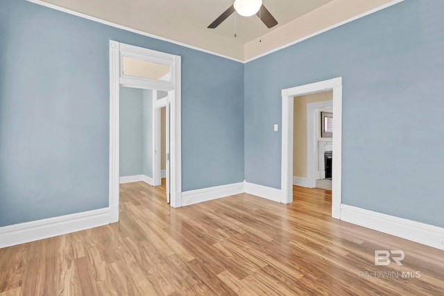 unfurnished room with baseboards, ceiling fan, and wood finished floors