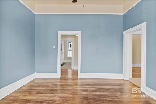 unfurnished room featuring baseboards, a ceiling fan, and wood finished floors