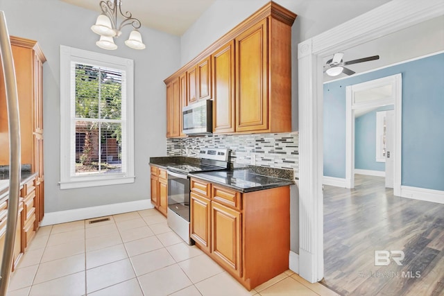 kitchen with visible vents, brown cabinetry, baseboards, tasteful backsplash, and stainless steel appliances